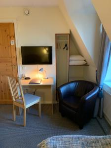 a room with a desk and a chair and a chair at Nya Pallas Hotel in Falkenberg