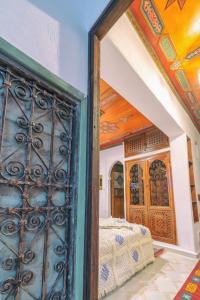 a bedroom with an open door with a bed at Dar Baibou in Chefchaouene