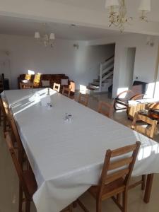 a living room with a large white table and chairs at Casa Bunicutei in Ranca