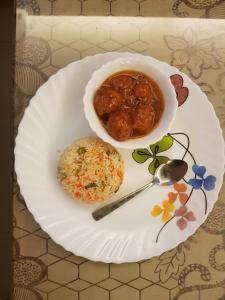un plato de comida con un plato de albóndigas y arroz en Hotel Vizima Palace - NEAR WAVE CITY CENTER METRO STATION, en Noida