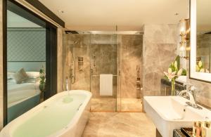 a bathroom with a tub and a sink and a shower at Taj Coromandel in Chennai