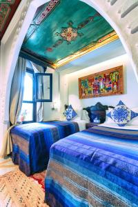 a bedroom with two beds and a ceiling at Dar Baibou in Chefchaouene