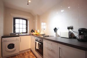 a kitchen with a sink and a washing machine at Marina Humber View Apartment in Hull