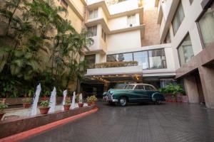 古瓦哈提Hotel Dynasty的停在大楼前的旧车