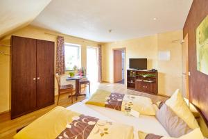 a hotel room with two beds and a television at Weingasthaus Wisser in Billigheim-Ingenheim