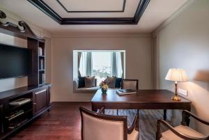 a hotel room with a desk and a television at Taj Coromandel in Chennai