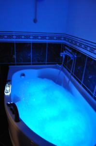 a bath tub filled with blue water in a bathroom at Comfort Deluxe Kosmos Apartments in Ohrid