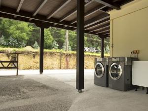 zwei Waschmaschinen befinden sich in einem Gebäude in der Unterkunft Albergue Piñeiral Fonsagrada in A Fonsagrada