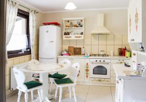 a kitchen with white appliances and a table and chairs at Casa Roua Muntilor in Câmpulung Moldovenesc