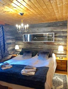 um quarto com uma cama grande e um lustre em Villa Karhunkehto em Luosto