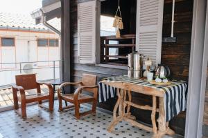 um quarto com uma mesa e cadeiras numa varanda em บ้านเสงี่ยม-มณี Baan Sa ngiam-Manee em Sakon Nakhon