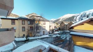 a view of a town in the snow from a building at La Dmura in Samedan