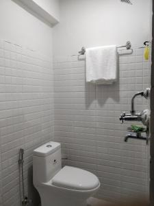 a white bathroom with a toilet and a towel at Hotel Samrajya Pvt. Ltd. in Kathmandu