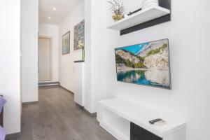a living room with white walls and a painting on the wall at Apartments Mate in Tučepi
