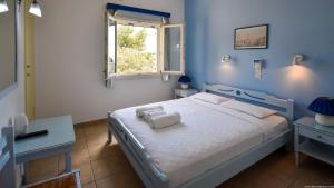 a blue bedroom with a bed and a window at Hotel Ivi in Drios
