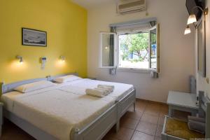 - une chambre avec un grand lit blanc et une fenêtre dans l'établissement Hotel Ivi, à Drios