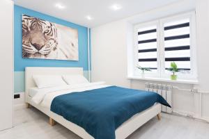 a bedroom with a bed with a painting of a tiger at Apartments Roomer in Minsk