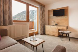 sala de estar con sofá y TV en Apart Pension Moos - inkl Super Sommer Card 2024 en Serfaus