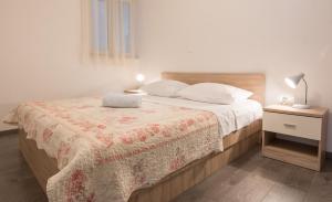 a bedroom with a bed with a blanket on it at Apartments Mate in Tučepi