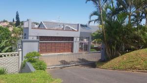 a white house with a fence and a street at SeA WaVes in Densainagar