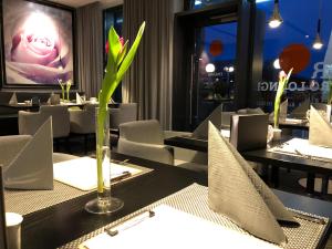 restauracja ze stołami i krzesłami oraz wazonem z rośliną w obiekcie Hotel Schempp w mieście Bobingen