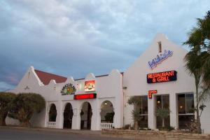 un edificio bianco con un cartello per un ristorante di Namaqua Lodge a Vanrhynsdorp