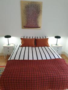 een slaapkamer met een bed met een rode deken en 2 lampen bij Stay Home Lisbon in Lissabon