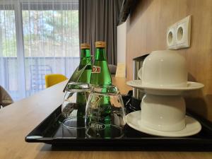 two green bottles on a tray on a table at 5 Zmysłów akademia wypoczynku Pokoje in Grzybowo