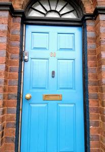 a blue front door of a brick building at Oxford Road in Macclesfield