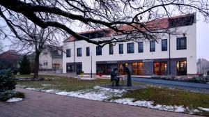 una pareja de pie en frente de un edificio en Ludwig Hotel, en Martonvásár