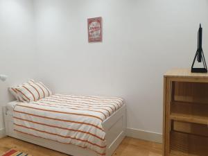 a bedroom with a bed with a striped blanket at Stay Home Lisbon in Lisbon