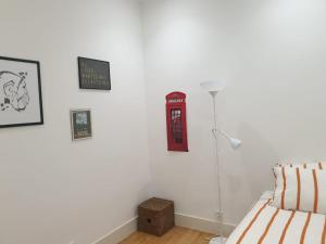 リスボンにあるステイ ホーム リスボンのベッドルーム1室(壁に赤い電話ブース付)