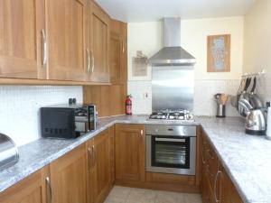 a kitchen with wooden cabinets and a stove top oven at 8 Cathedral Street in Dunkeld