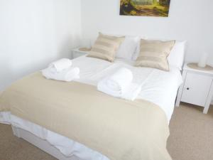 Una cama blanca con sábanas blancas y almohadas. en 8 Cathedral Street en Dunkeld