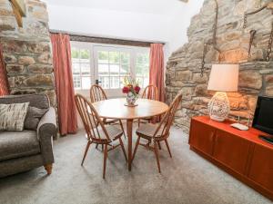 ein Wohnzimmer mit einem Tisch, Stühlen und einem Sofa in der Unterkunft Treverbyn Smithy in Saint Neot