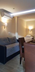 a hotel room with two beds and a chair at Central Panzió Gyula in Gyula