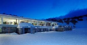 a large building in the snow at night at Smiggins Hotel & Chalet Apartments in Perisher Valley