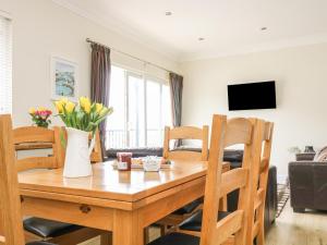 a dining room and living room with a wooden table and chairs at Rivercrest in Looe