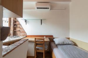 eine kleine Küche mit einem Sofa und einem Tisch in einem Zimmer in der Unterkunft Cozy, Bright and Affordable Single Studio - Free Parking in Ljubljana