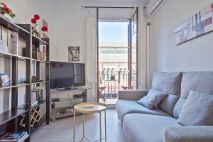 a living room with a couch and a tv at Apartamento Sant Gervasi in Barcelona