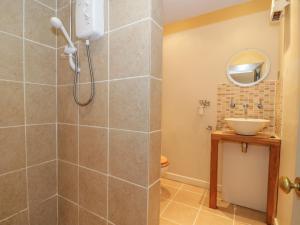 ein Badezimmer mit Dusche und Waschbecken in der Unterkunft Pembridge Cottage in Llanrothal + 10 Fotos