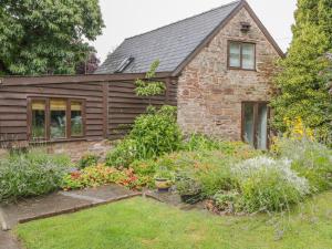 una casa con un jardín delante de ella en Pembridge Cottage, en Llanrothal