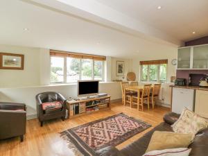 ein Wohnzimmer mit Sofa und Fernseher in der Unterkunft Pembridge Cottage in Llanrothal