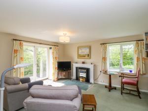 a living room with two couches and a fireplace at Old Ford Farm Annexe in Widworthy