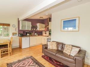 sala de estar con sofá y cocina en Pembridge Cottage, en Llanrothal