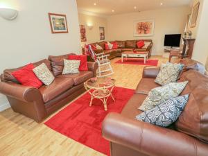a living room with leather couches and a table at Laurel Bank Cottage in Embsay