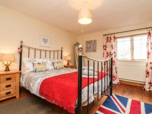 a bedroom with a bed and a red blanket at Little Dragons in Dunster