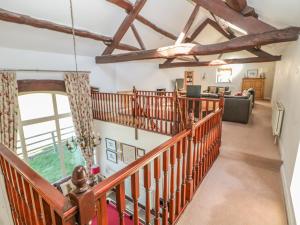 an ascending staircase in a house with wooden beams at Bullace Barn in Thurlstone