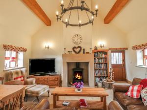 a living room with a fireplace and a chandelier at The Cow Barn in Stanton in Peak