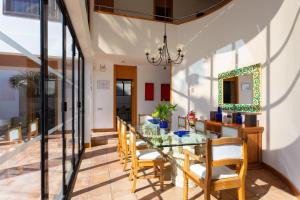 uma sala de jantar com uma mesa de vidro e cadeiras em ViVaTenerife - Immense villa, unique and exclusive em Chayofa